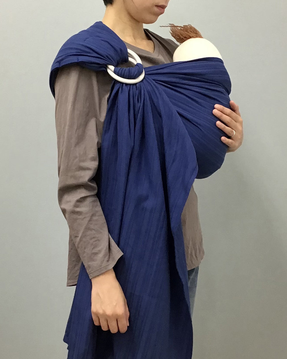 スリング　キュット ミー！823カマイユ／ジャパンブルーで赤ちゃんを抱っこするお母さん